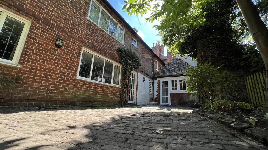 Brick-front house with paved courtyard and matu...