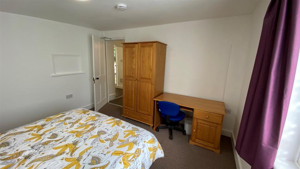 Bright bedroom with bed, desk and wardrobe...