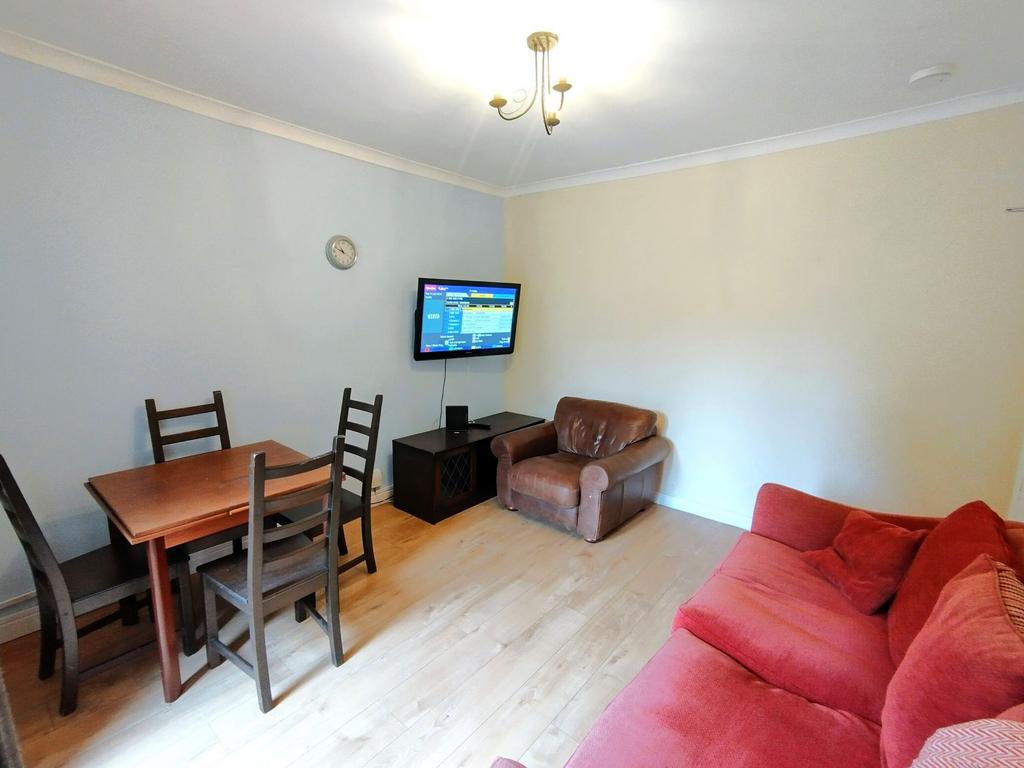 Bright furnished living room with a red sofa, l...