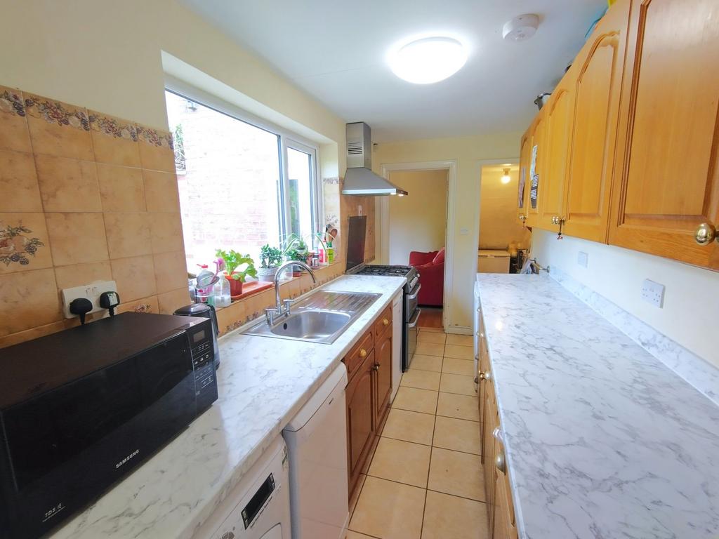 Bright galley kitchen with white marble-effect ...