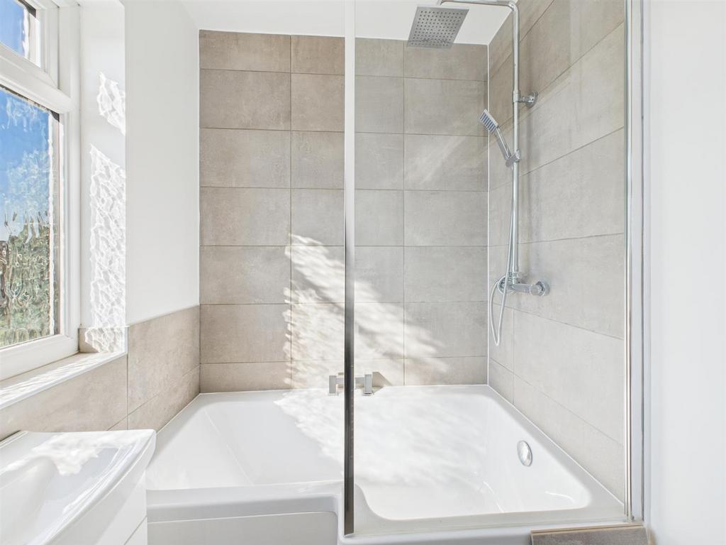 Bright bathroom with modern shower and full bat...
