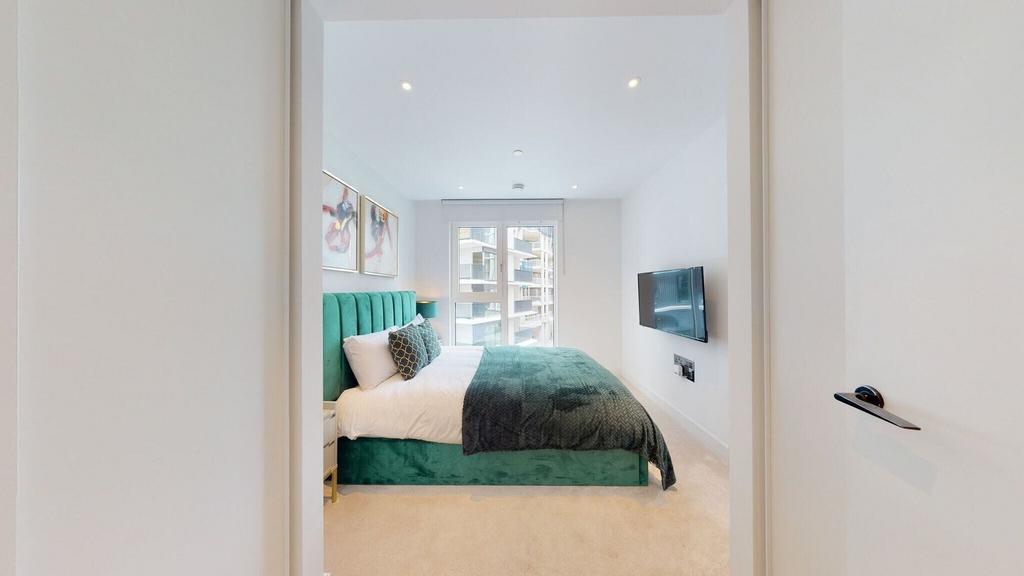 Bright modern bedroom with plush green bed...