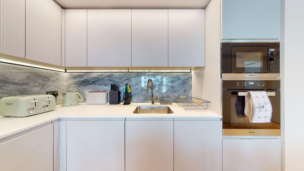Sleek fitted kitchen with marble splashback...