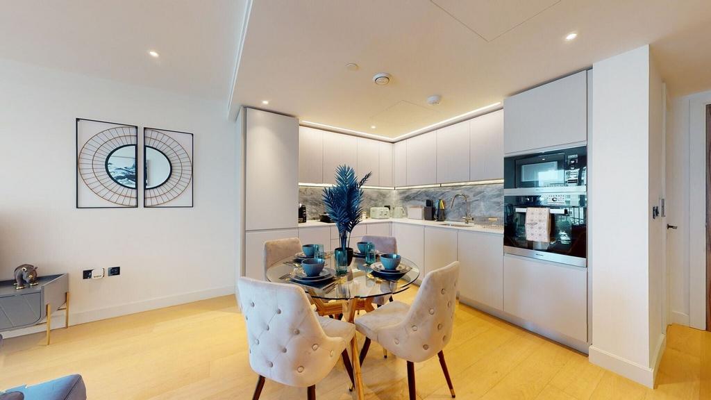 Modern fitted kitchen with glass dining table...