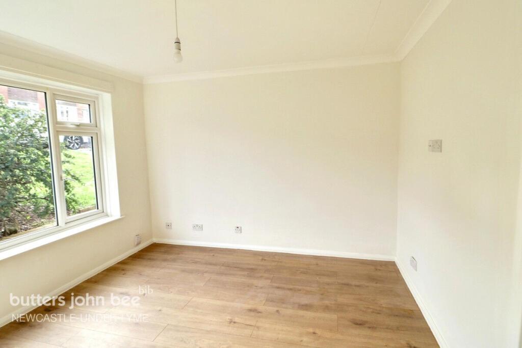 Bright bedroom with large window and wood floor...