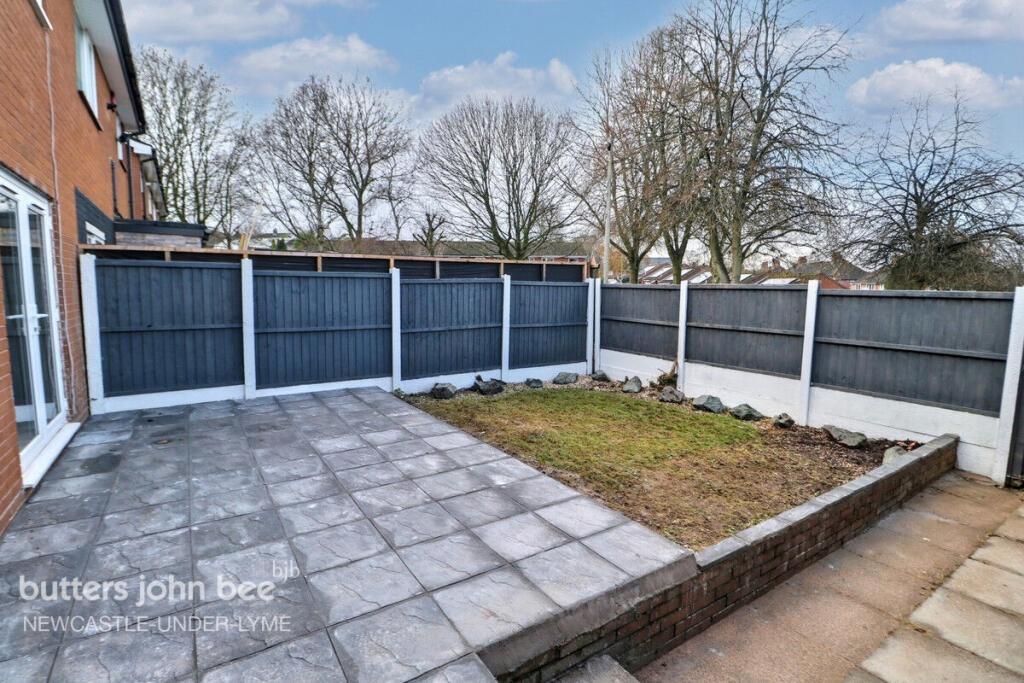 Private paved patio with small lawn and fencing...