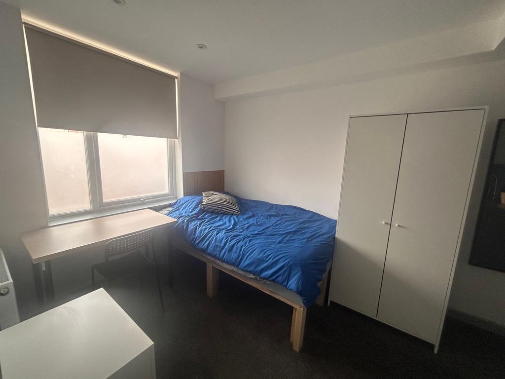 Bright single room with desk and wardrobe...