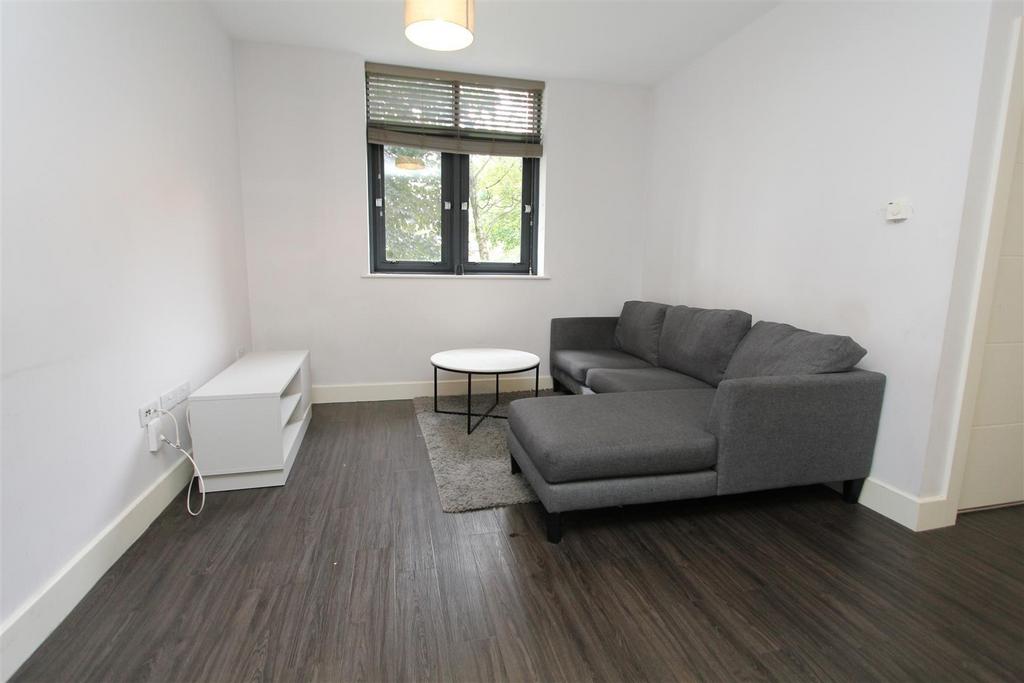 Bright lounge with sleek dark wood flooring...