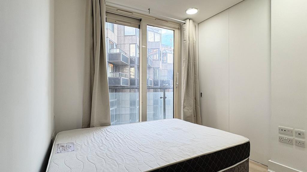 Bright modern bedroom with a Juliet balcony...