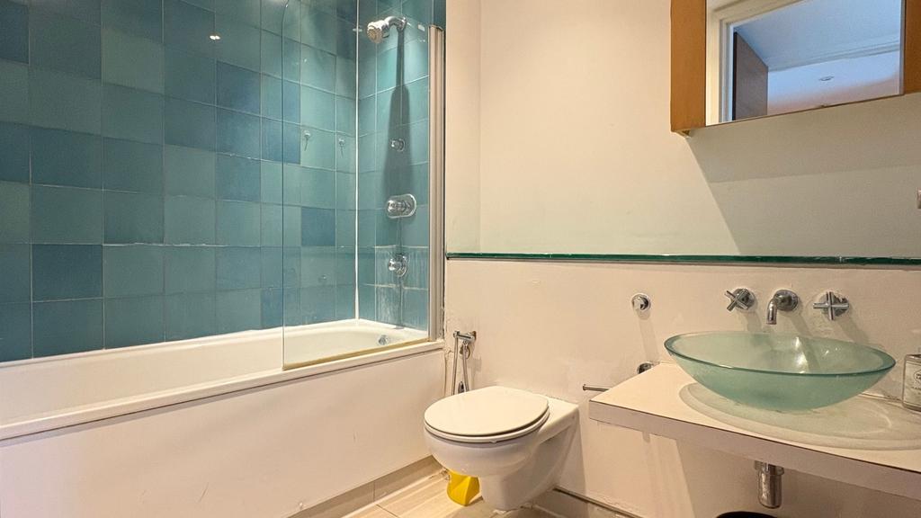 Modern bathroom with stylish glass basin and ba...