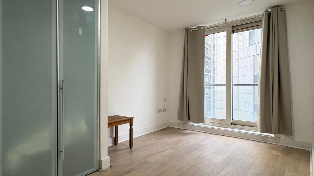 Bright bedroom with large floor-to-ceiling wind...