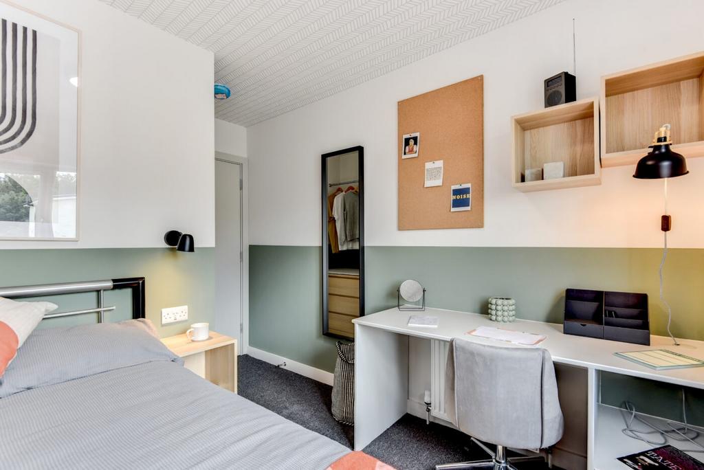 Bright, neatly styled bedroom with a comfortabl...