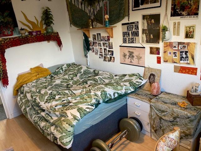 Cozy double bedroom with leafy-pattern bedding,...
