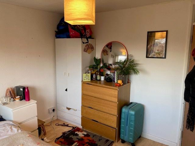 Bright, tidy bedroom corner with a wooden chest...