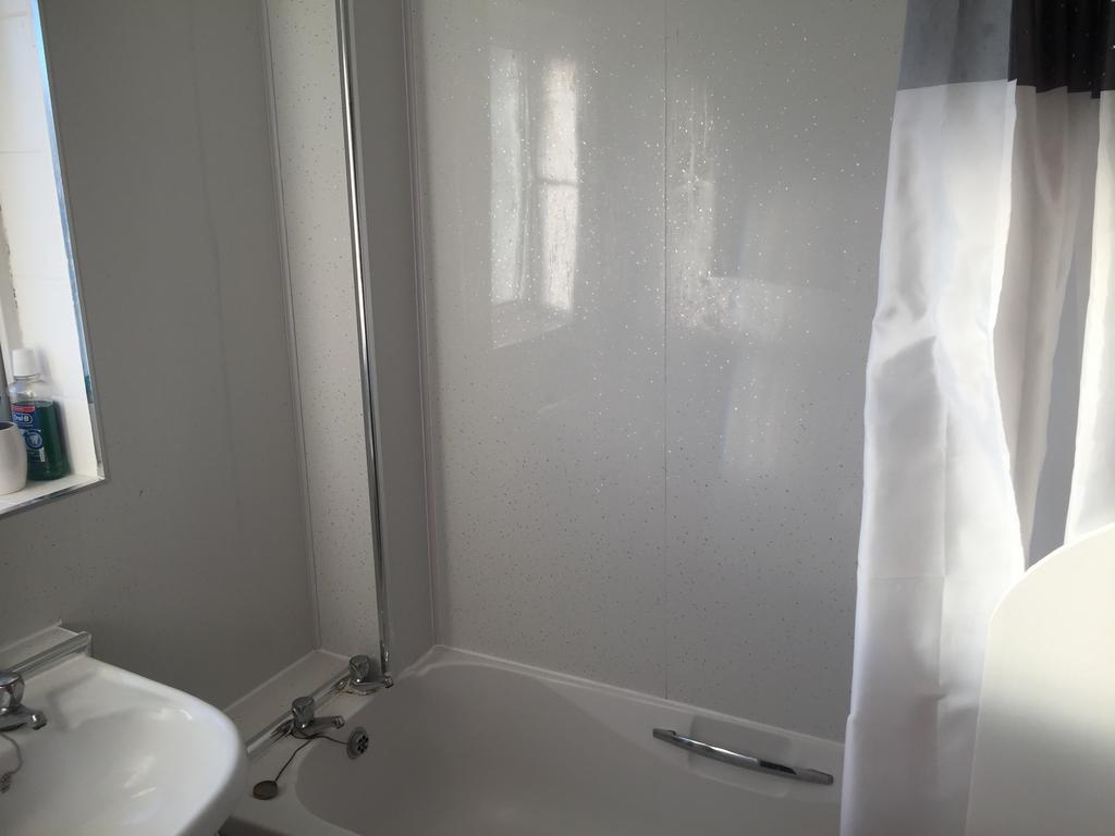 Bright, modern bathroom with a white bathtub, s...