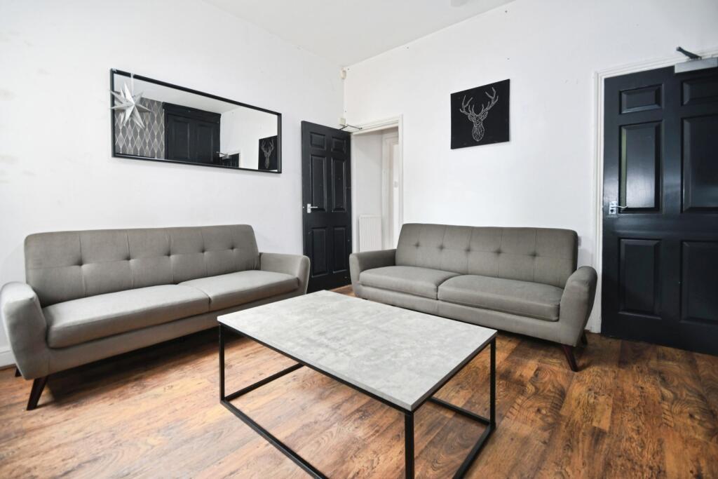 Contemporary furnished living room with two mat...