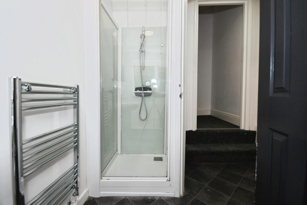 Modern bathroom with a glass-enclosed shower, c...