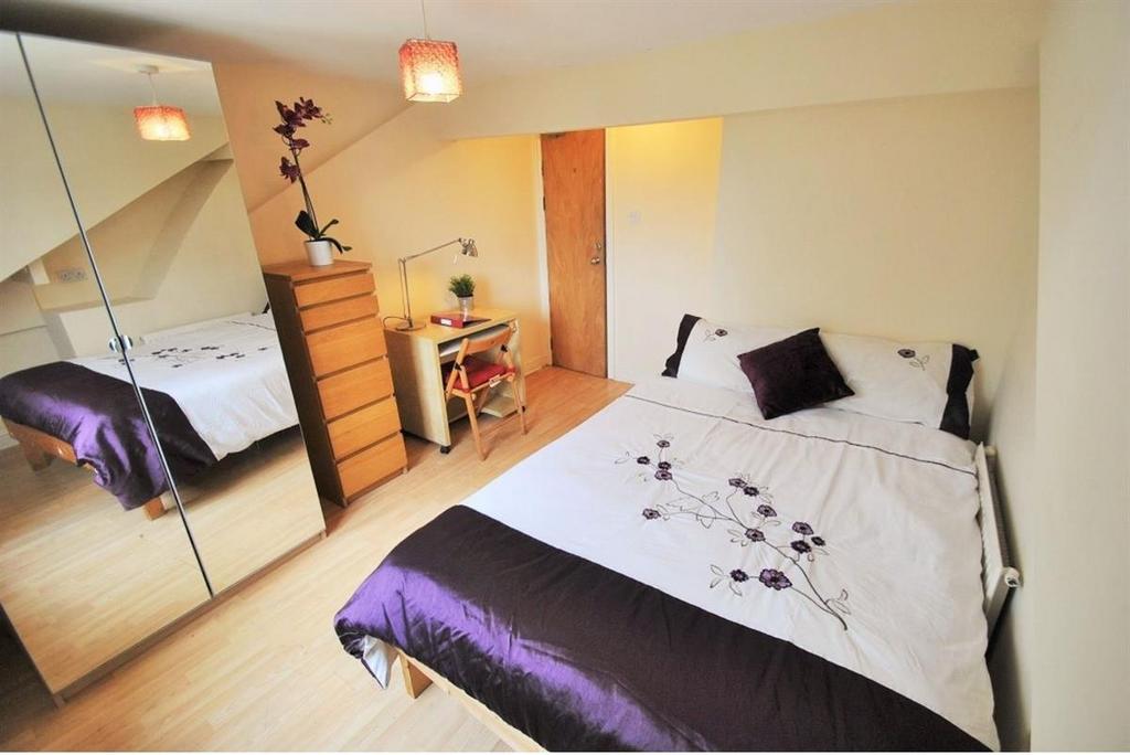 Bright bedroom with study desk and mirrored rob...