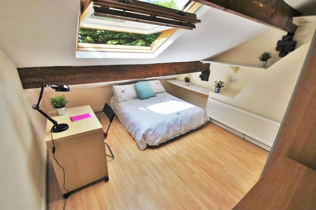 Bright loft bedroom with desk and skylight...