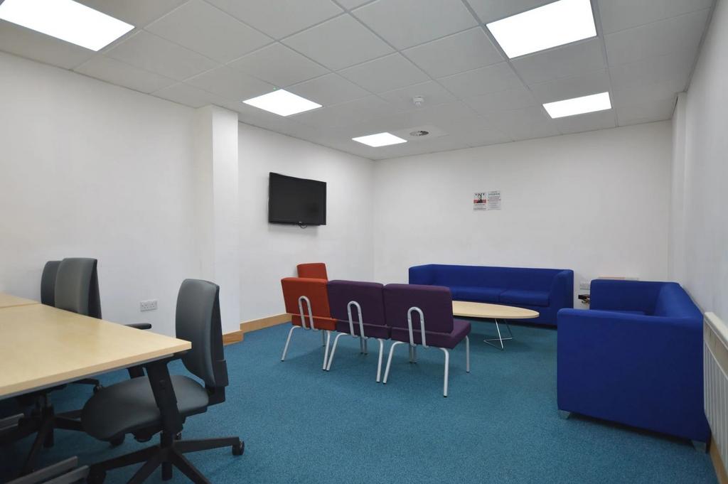 Spacious lounge with social seating and TV...