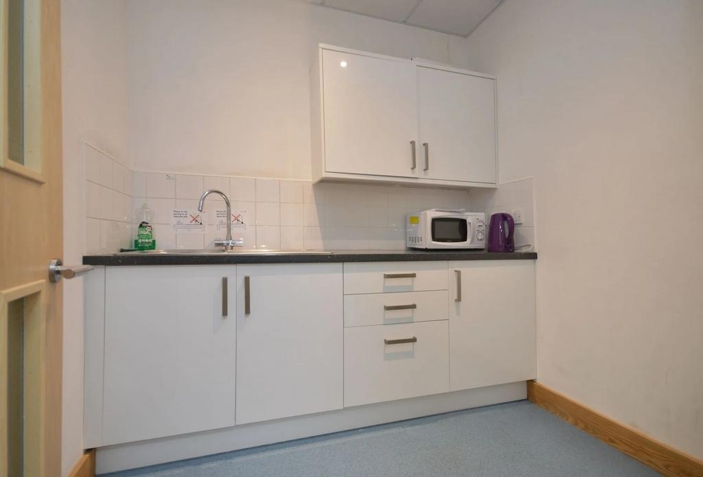 Modern kitchenette with sleek white cabinetry...