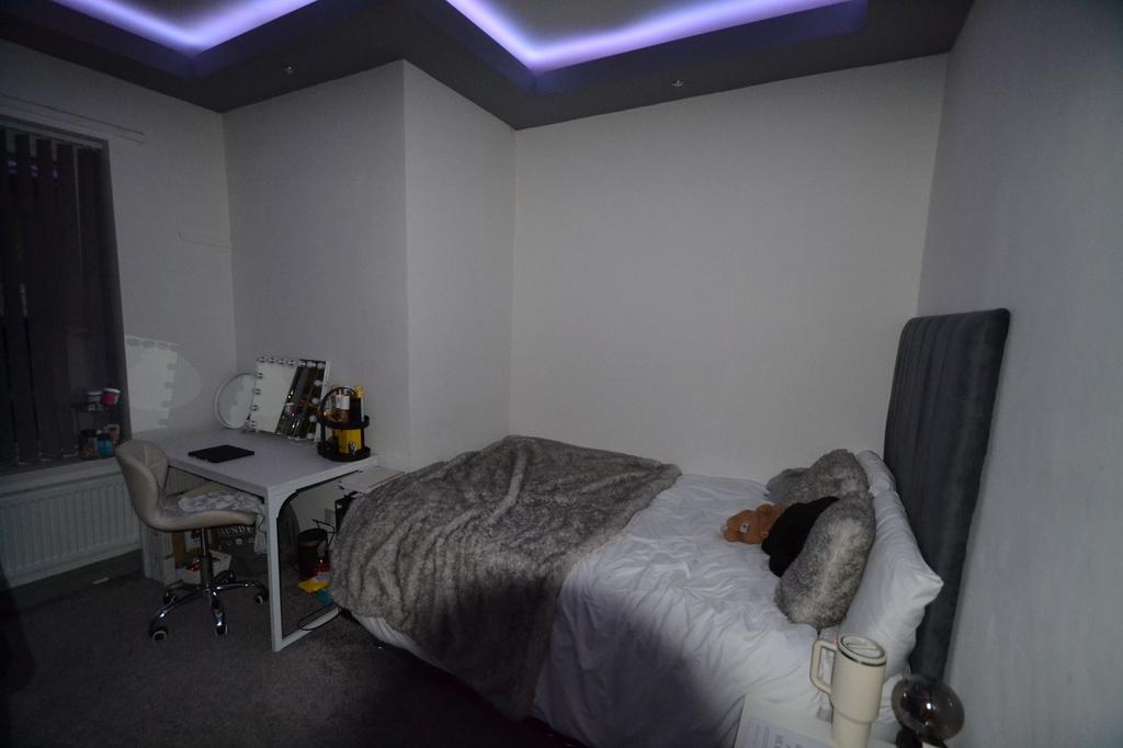 Comfortable double bedroom with a plush upholst...
