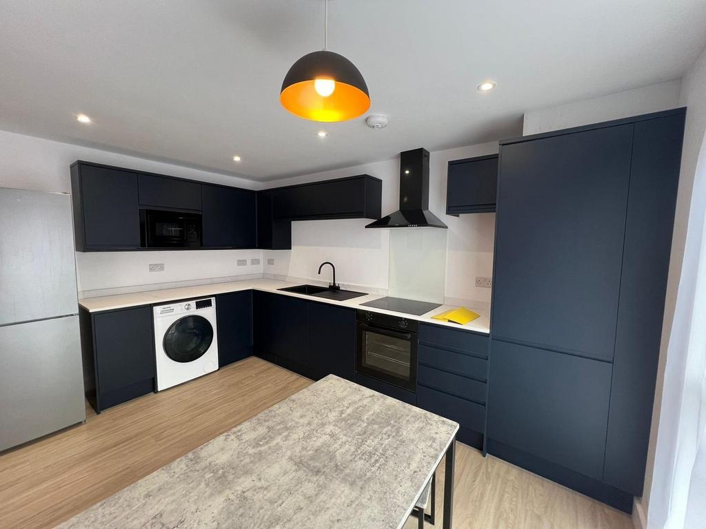 Modern dark‑navy kitchen with integrated white ...