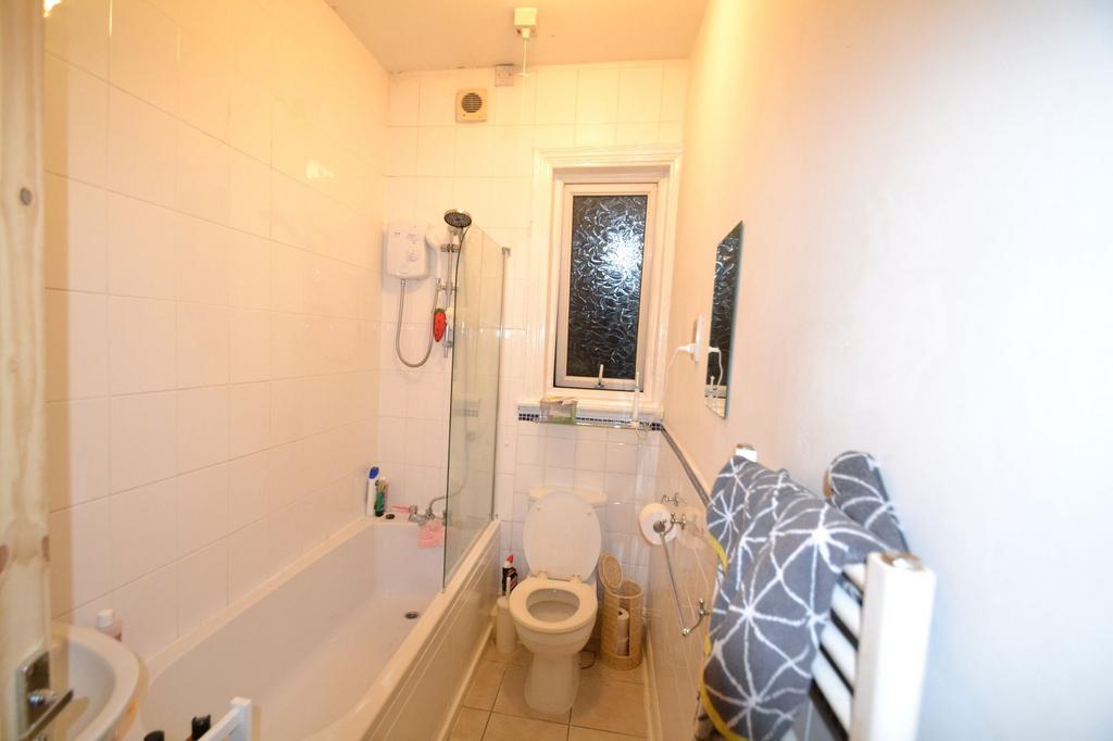 A clean and functional bathroom with a bathtub,...