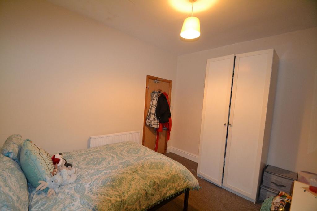 A cozy double bedroom featuring a bed with patt...