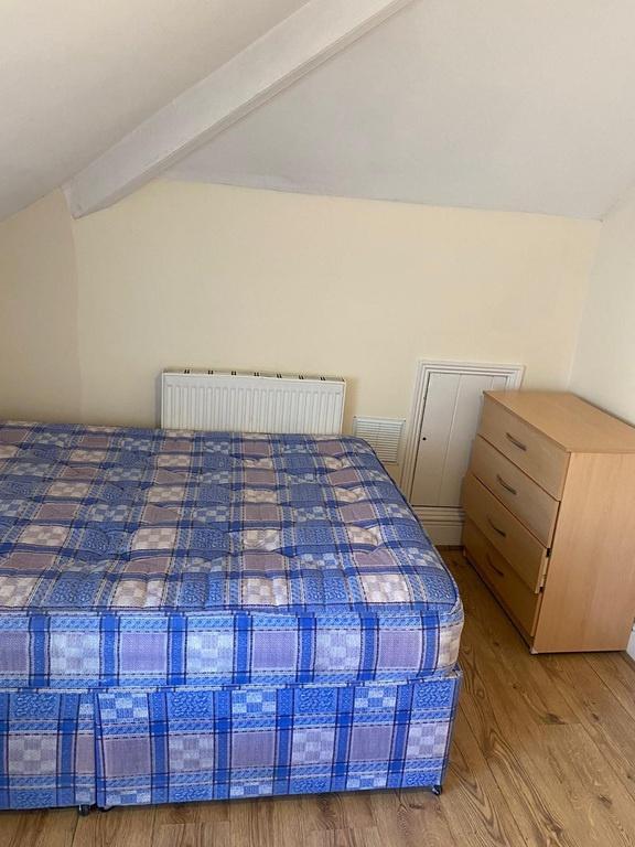 Bright bedroom with wooden floors and storage...