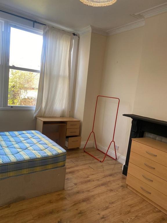 Bright bedroom with desk and ample storage spac...