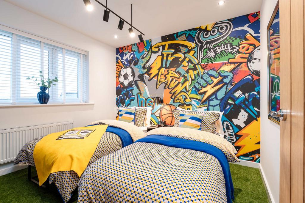 Two beds with colorful bedding are in the...