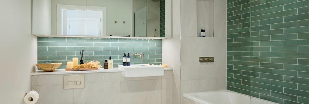 Shower over bath, sea green tiling, wash basin...