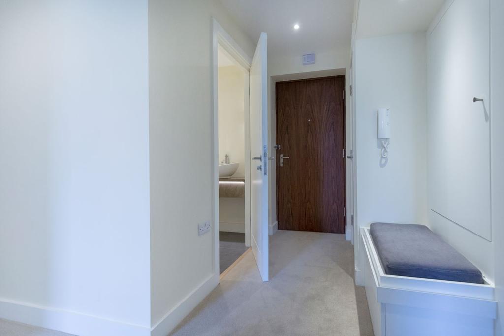 Entrance hallway with feature wallpaper, wall lights and a handy storage seat