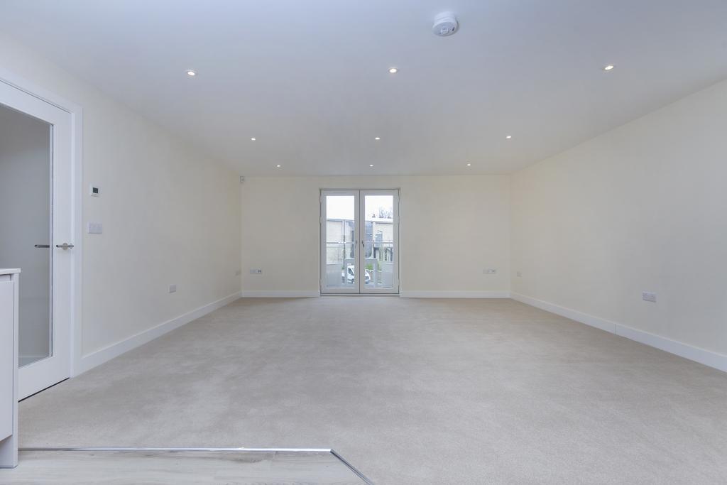 Spacious living kitchen with french doors to a balcony with glass balustrading