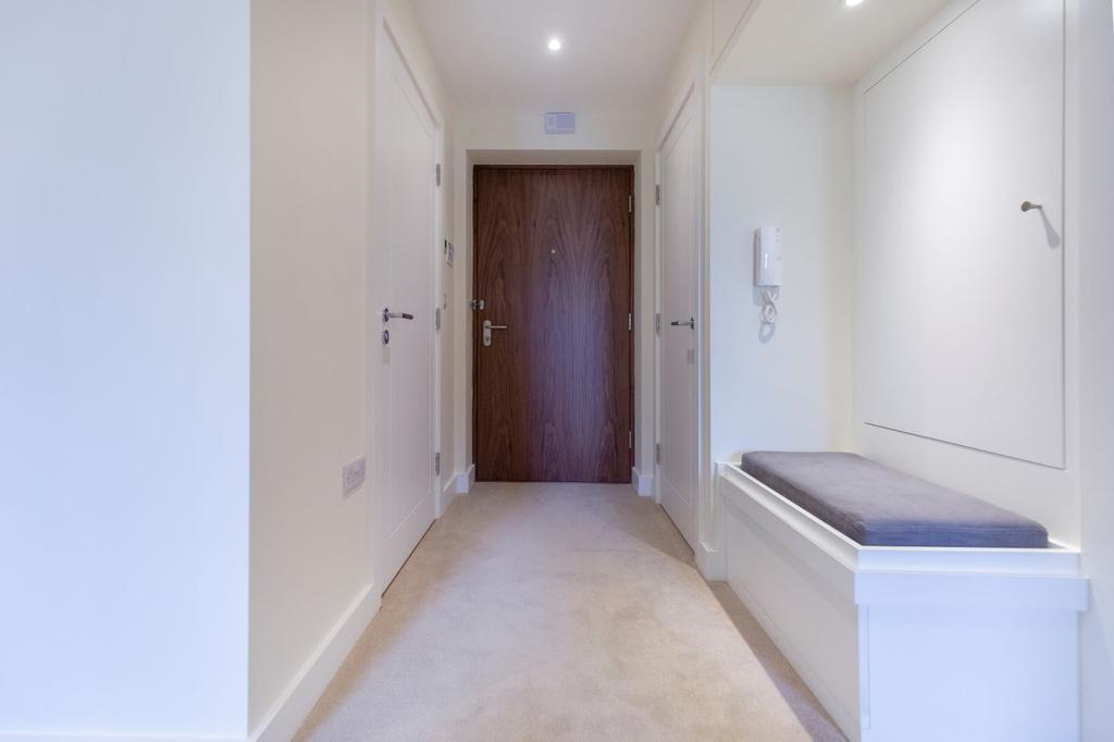 Entrance hallway with a storage seat and a glass feature length door through to the living area