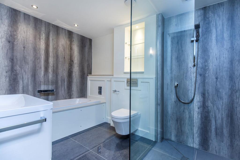 Bathroom with decorative wood panelling and dark marble splash walls to the shower and fitted bath